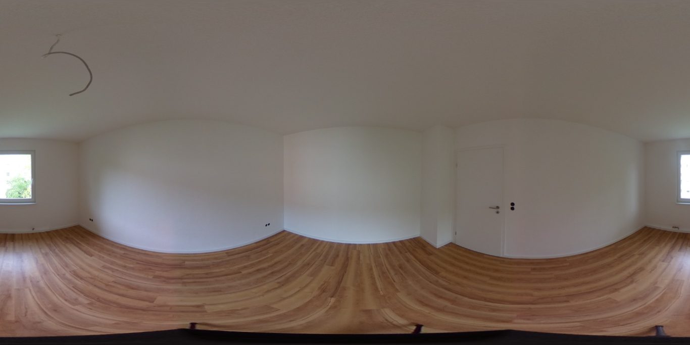 Nachher Leere, hell beleuchtete Raumansicht mit Holzfußboden und weißen Wänden.
